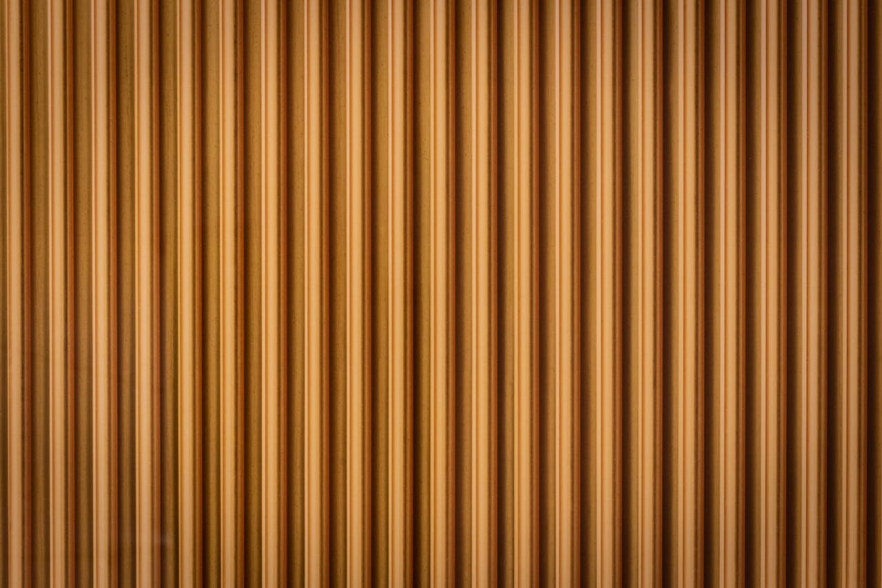 about-img Close-up of a corrugated wooden wall with a rich brown texture, creating a geometric pattern.